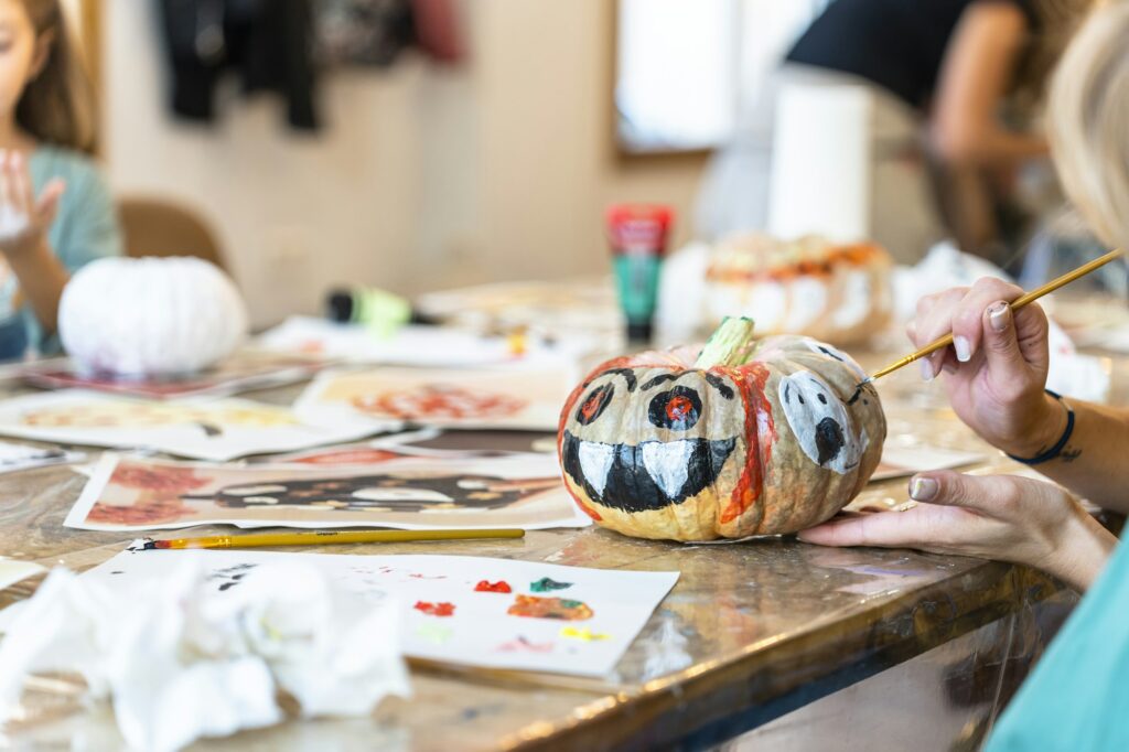 Children's painting class. Painting day with parents in class painting pumpkins.