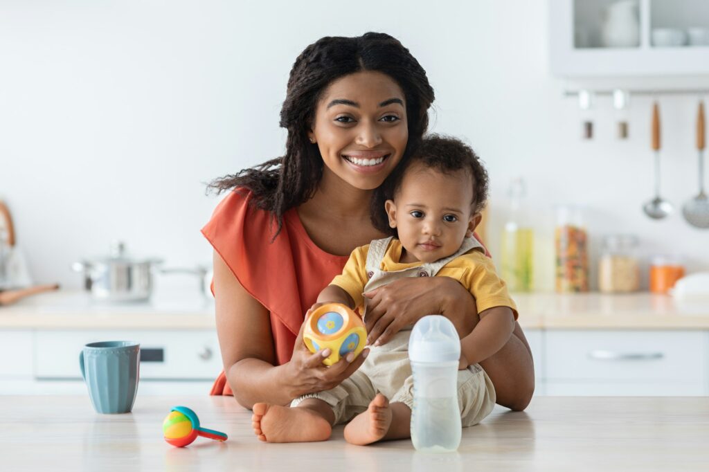 Happy Young African American Mother And Cute Toddler Baby Posing In Kitchen